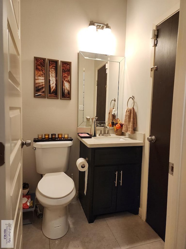 bathroom with tile patterned floors, vanity, and toilet