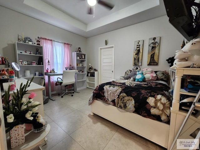 bedroom featuring tile patterned flooring, ceiling fan, and a tray ceiling