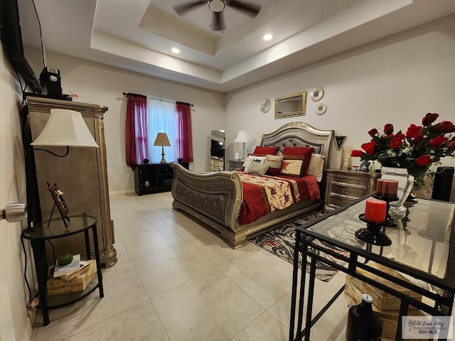 tiled bedroom with a raised ceiling and ceiling fan