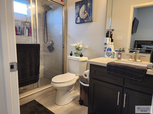 bathroom with tile patterned floors, vanity, toilet, and a shower with shower door