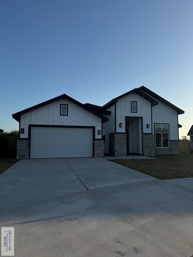 9464 S Queen Palm, Los Fresnos, TX 78566 - view of front of home with board and batten siding, driveway, and stone siding
