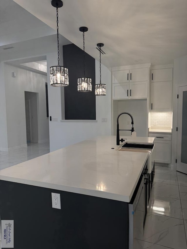 9464 S Queen Palm, Los Fresnos, TX 78566 - kitchen featuring a sink, light marble finish flooring, a chandelier, tasteful backsplash, and a kitchen island with sink