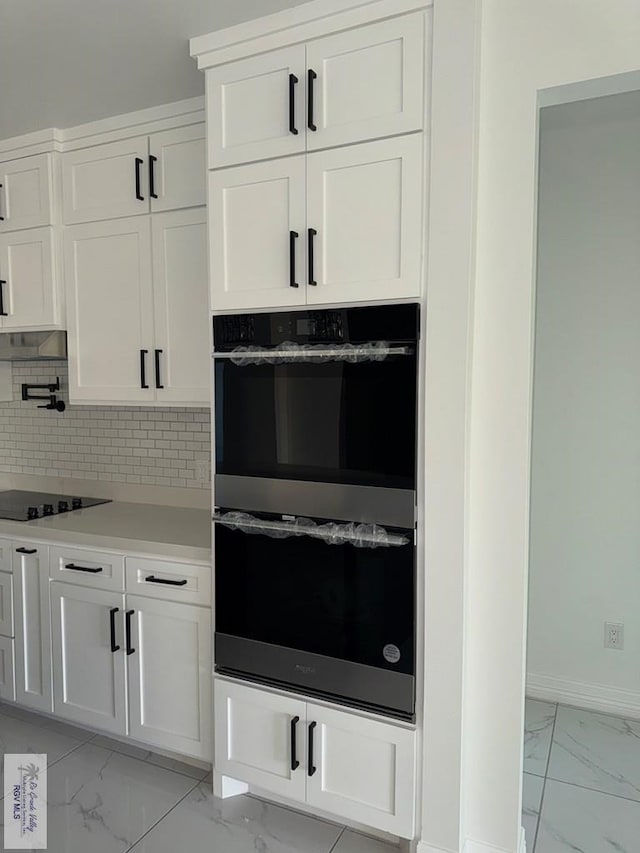 9464 S Queen Palm, Los Fresnos, TX 78566 - kitchen with multiple ovens, light marble finish flooring, black electric cooktop, white cabinets, and light countertops