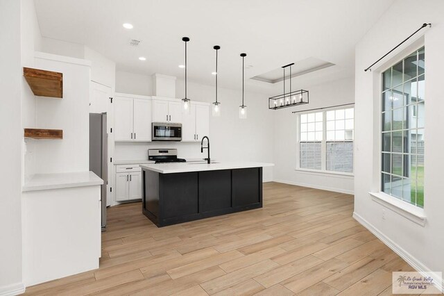 3515 S Elevation Dr, Edinburg, TX 78542 - kitchen with stainless steel appliances, a sink, white cabinets, light wood-style flooring, and recessed lighting