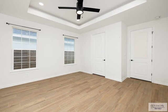 3515 S Elevation Dr, Edinburg, TX 78542 - unfurnished bedroom featuring a raised ceiling, light wood-style floors, baseboards, a ceiling fan, and recessed lighting