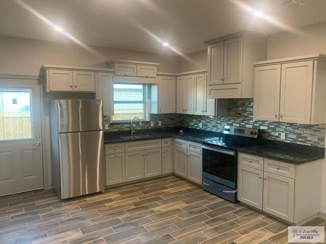 kitchen with sink, dark hardwood / wood-style floors, gray cabinets, decorative backsplash, and stainless steel appliances