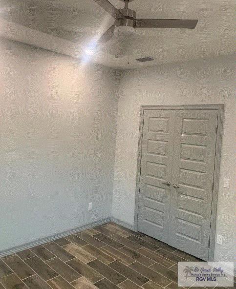 spare room featuring ceiling fan and dark hardwood / wood-style flooring