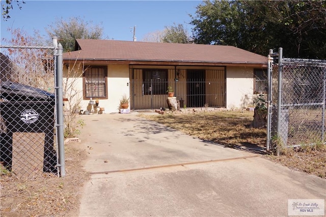 view of front of property featuring stucco siding, concrete driveway, and fence