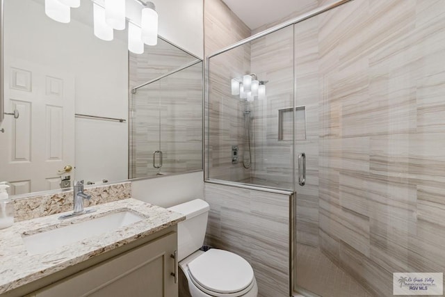 bathroom featuring walk in shower, vanity, and toilet