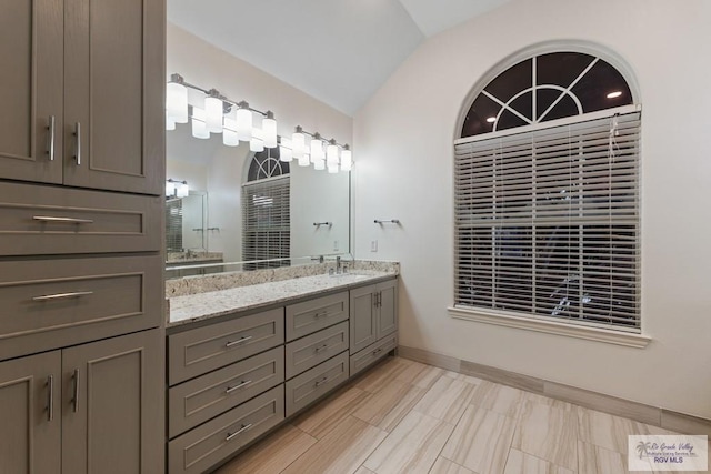 bathroom with vanity and vaulted ceiling