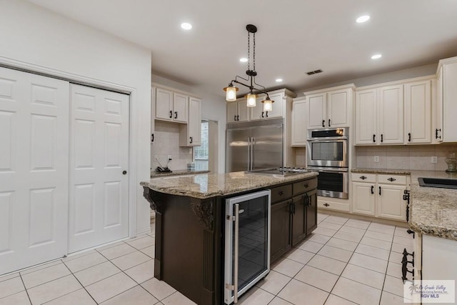 kitchen featuring tasteful backsplash, stainless steel appliances, a center island, wine cooler, and hanging light fixtures