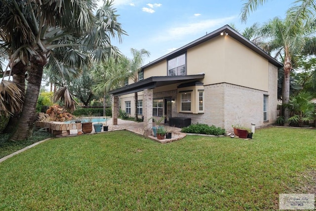 back of house featuring a patio area and a yard