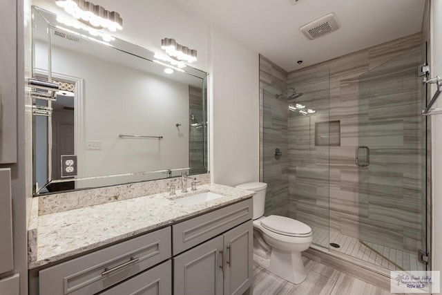 bathroom featuring vanity, toilet, and walk in shower