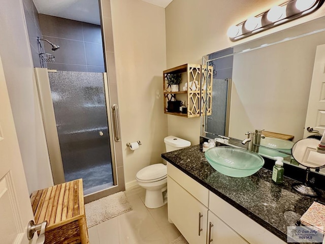 bathroom featuring a stall shower, vanity, toilet, and tile patterned floors