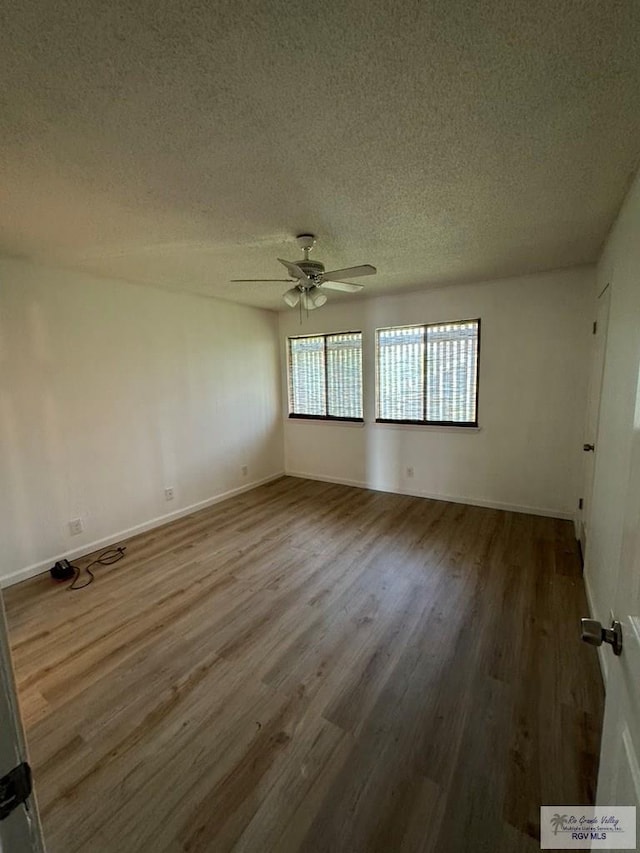 spare room with ceiling fan, wood-type flooring, and a textured ceiling