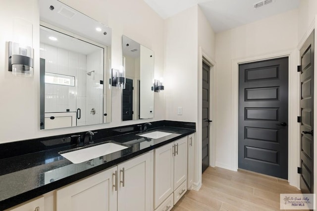 bathroom featuring vanity, hardwood / wood-style flooring, and a shower with shower door