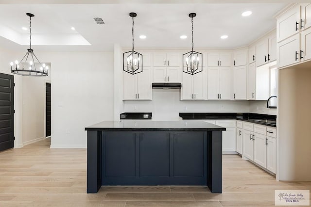 kitchen with sink, pendant lighting, light hardwood / wood-style flooring, white cabinets, and a center island