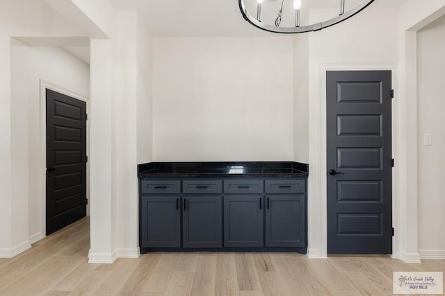 1209 Bridle Way, San Benito, TX 78586 - kitchen featuring light wood-style floors, dark stone countertops, and gray cabinetry