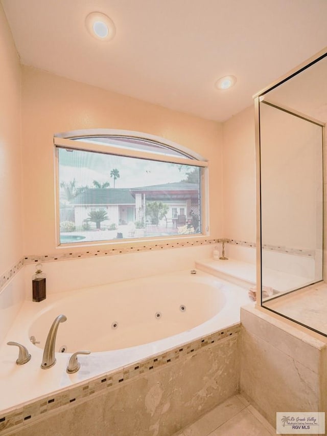 bathroom featuring tile patterned floors and tiled bath