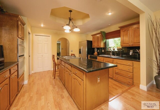 kitchen with a center island, light hardwood / wood-style floors, stainless steel appliances, and tasteful backsplash