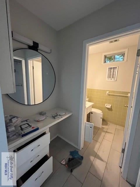 bathroom featuring tile patterned flooring, vanity, and tile walls