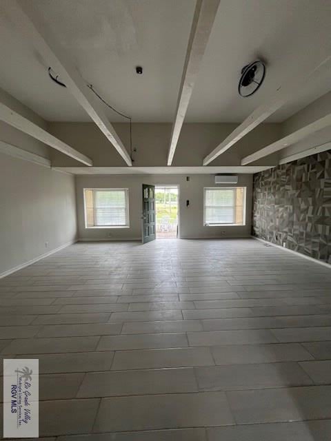 unfurnished room with beamed ceiling and a healthy amount of sunlight