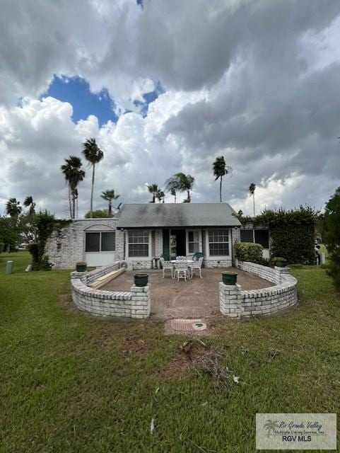 rear view of house featuring a lawn and a patio area