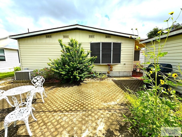 rear view of property featuring a patio and central AC