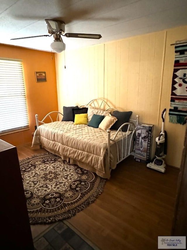 bedroom with dark hardwood / wood-style flooring and ceiling fan