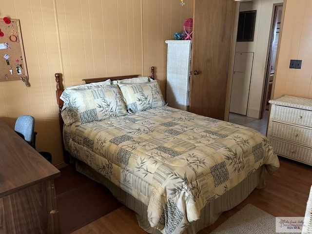 bedroom with wooden walls and light wood-type flooring