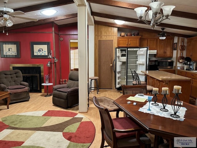 dining room with light hardwood / wood-style flooring, lofted ceiling with beams, and ceiling fan with notable chandelier