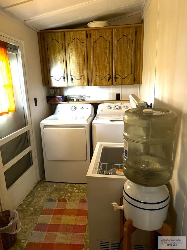 washroom featuring cabinets and independent washer and dryer