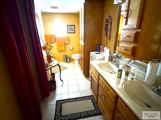 bathroom with tile patterned flooring, vanity, and toilet