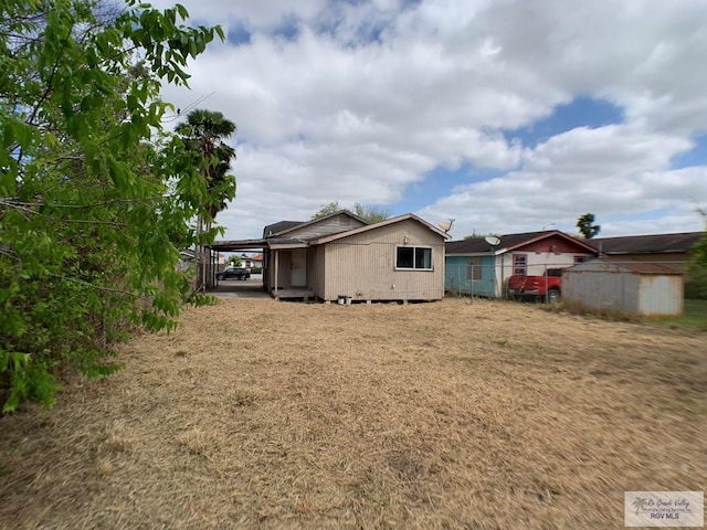 rear view of house featuring an outbuilding and an attached carport