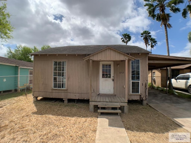 view of outbuilding featuring concrete driveway and a carport