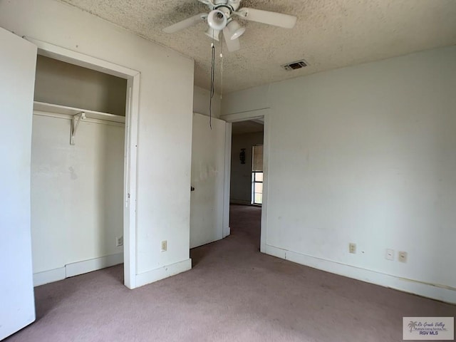 unfurnished bedroom with visible vents, carpet, a closet, and a textured ceiling