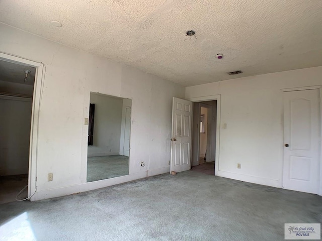 unfurnished bedroom featuring a closet, visible vents, a textured ceiling, and baseboards