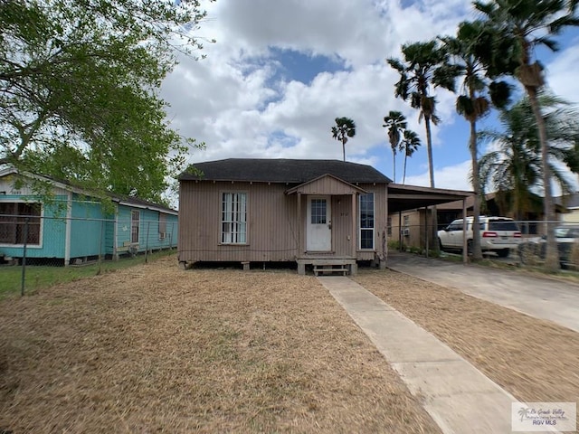 view of front of property featuring an attached carport, entry steps, concrete driveway, and fence