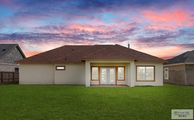 32722 Jorge St, Los Fresnos, TX 78566 - back of house at dusk with french doors, stucco siding, and a shingled roof