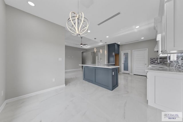 32722 Jorge St, Los Fresnos, TX 78566 - kitchen with a chandelier, recessed lighting, tasteful backsplash, light marble finish flooring, and light countertops