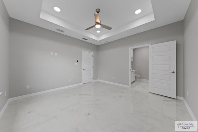 32722 Jorge St, Los Fresnos, TX 78566 - unfurnished bedroom featuring light marble finish floors, a tray ceiling, recessed lighting, connected bathroom, and a ceiling fan