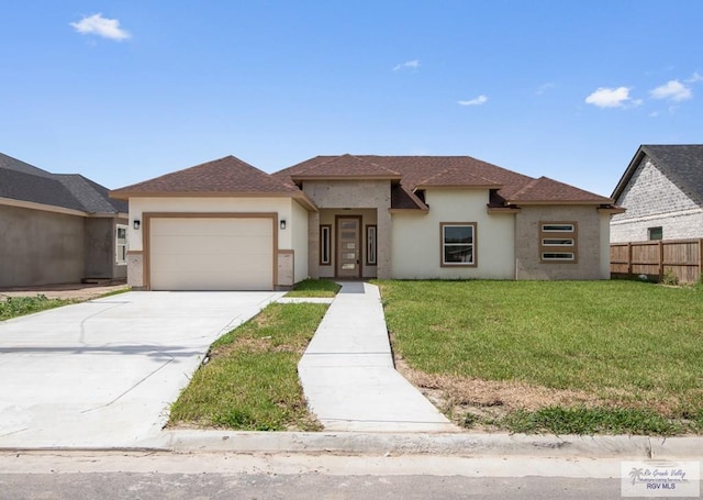 32722 Jorge St, Los Fresnos, TX 78566 - view of front facade with stucco siding, an attached garage, concrete driveway, and roof with shingles