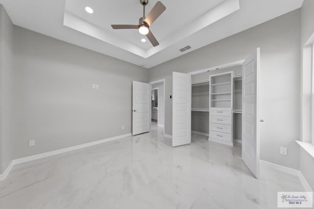 32722 Jorge St, Los Fresnos, TX 78566 - unfurnished bedroom with a tray ceiling, light marble finish floors, recessed lighting, a closet, and a spacious closet