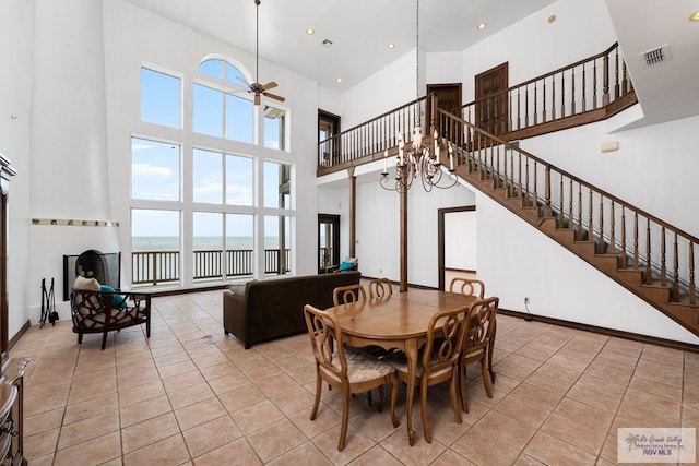 1810 N Shore Dr, Port Isabel, TX 78578 - tiled dining room with a towering ceiling, a ceiling fan, a water view, stairway, and recessed lighting