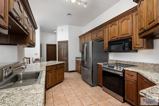 1810 N Shore Dr, Port Isabel, TX 78578 - kitchen featuring stainless steel appliances, light tile patterned floors, and light stone countertops