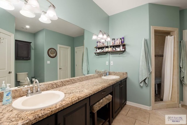 bathroom with a shower with shower curtain, vanity, tile patterned floors, and toilet