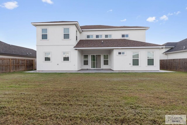 rear view of house featuring a lawn and a patio area