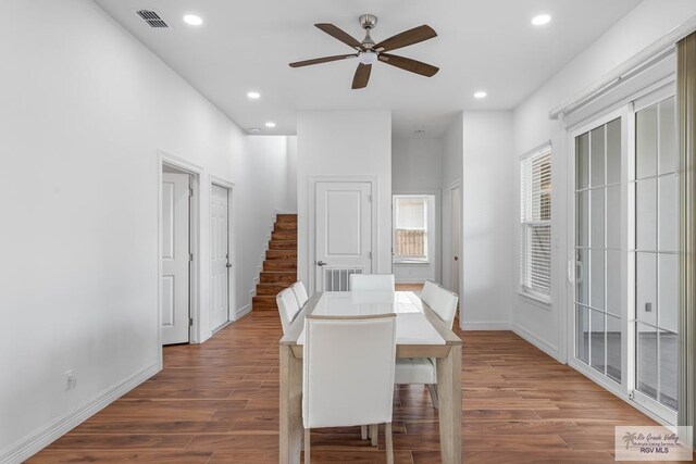 dining space featuring wood-type flooring and ceiling fan