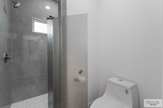 bathroom with tiled shower and toilet