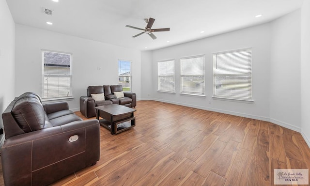 living room featuring light hardwood / wood-style floors and ceiling fan